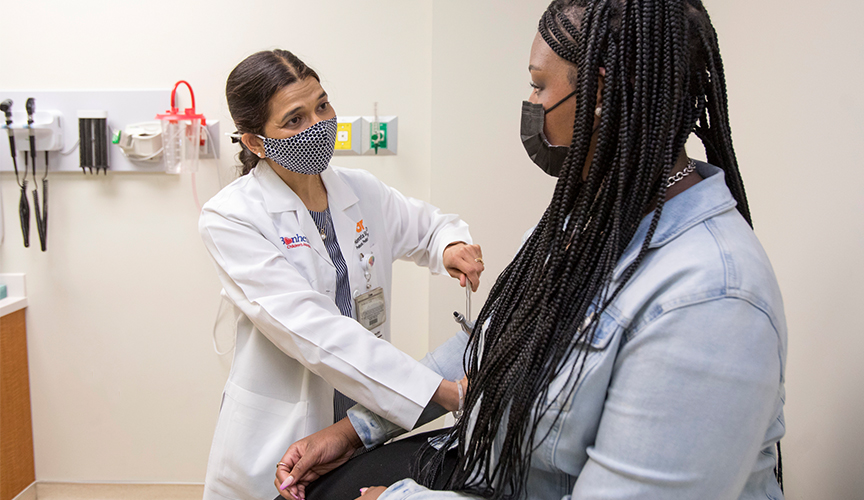 Le Bonheur neurologists examines a multiple sclerosis patient in clinic.